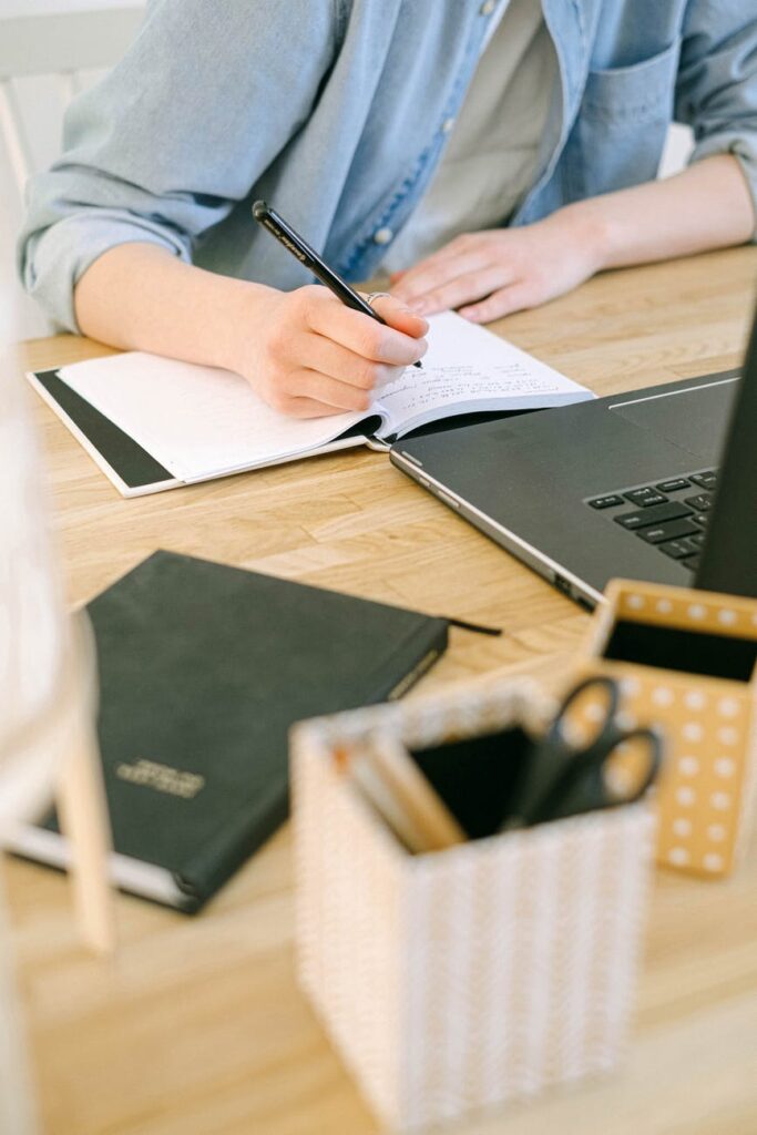 person writing on a notebook